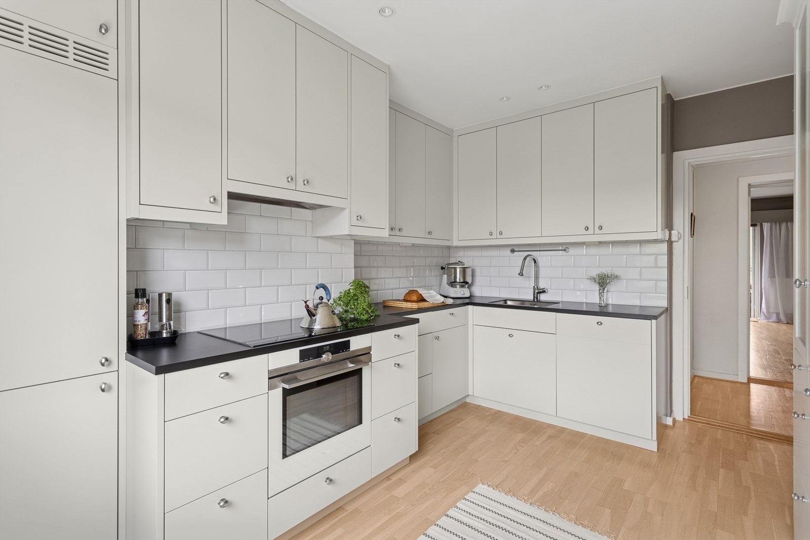 Kjøkkenet har en stilren og praktisk utforming med hvite skapfronter som gir et rent og tidløst uttrykk. Galleribilde