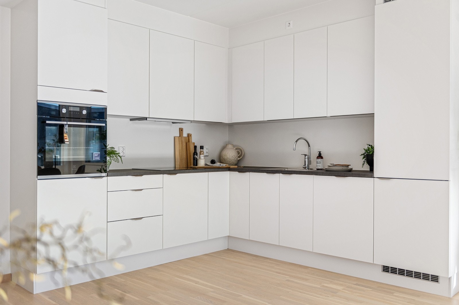 Integrerte hvitevarer som oppvaskmaskin, kombiskap med kjøl-/frys, komfyrtopp og ovn praktisk plassert i høyskap Galleribilde