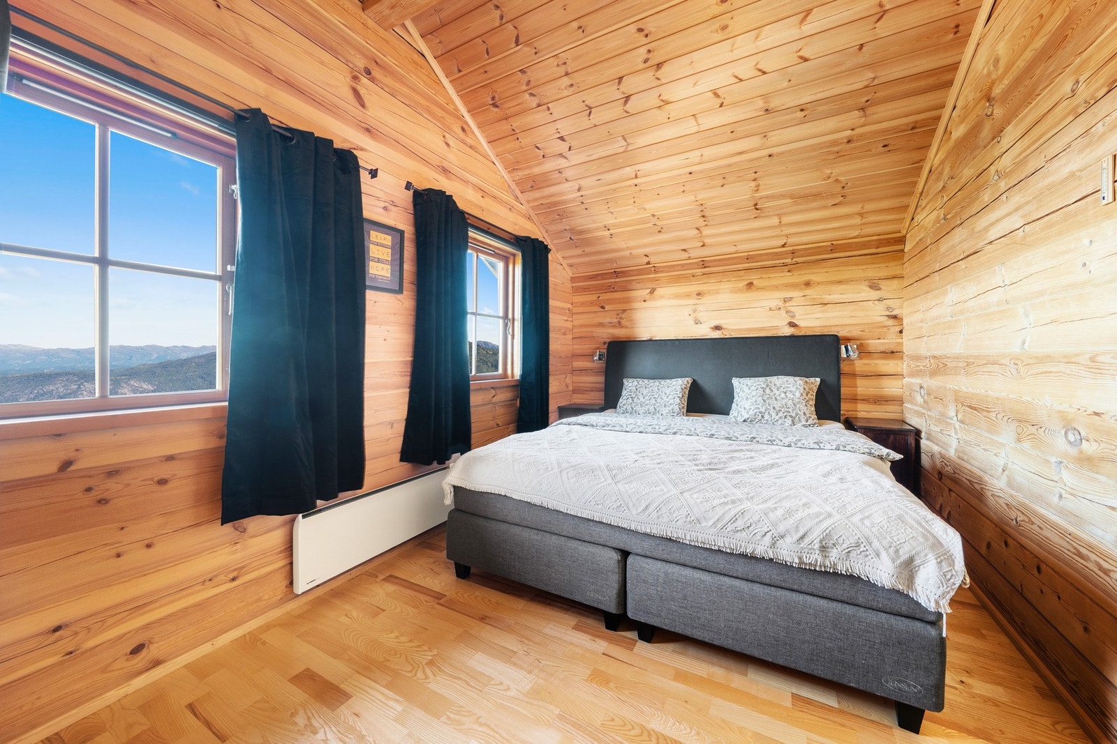 Romslig soverom med god takhøyde, naturlige materialvalg og rikelig med dagslys, som skaper en rolig og innbydende atmosfære. Galleribilde