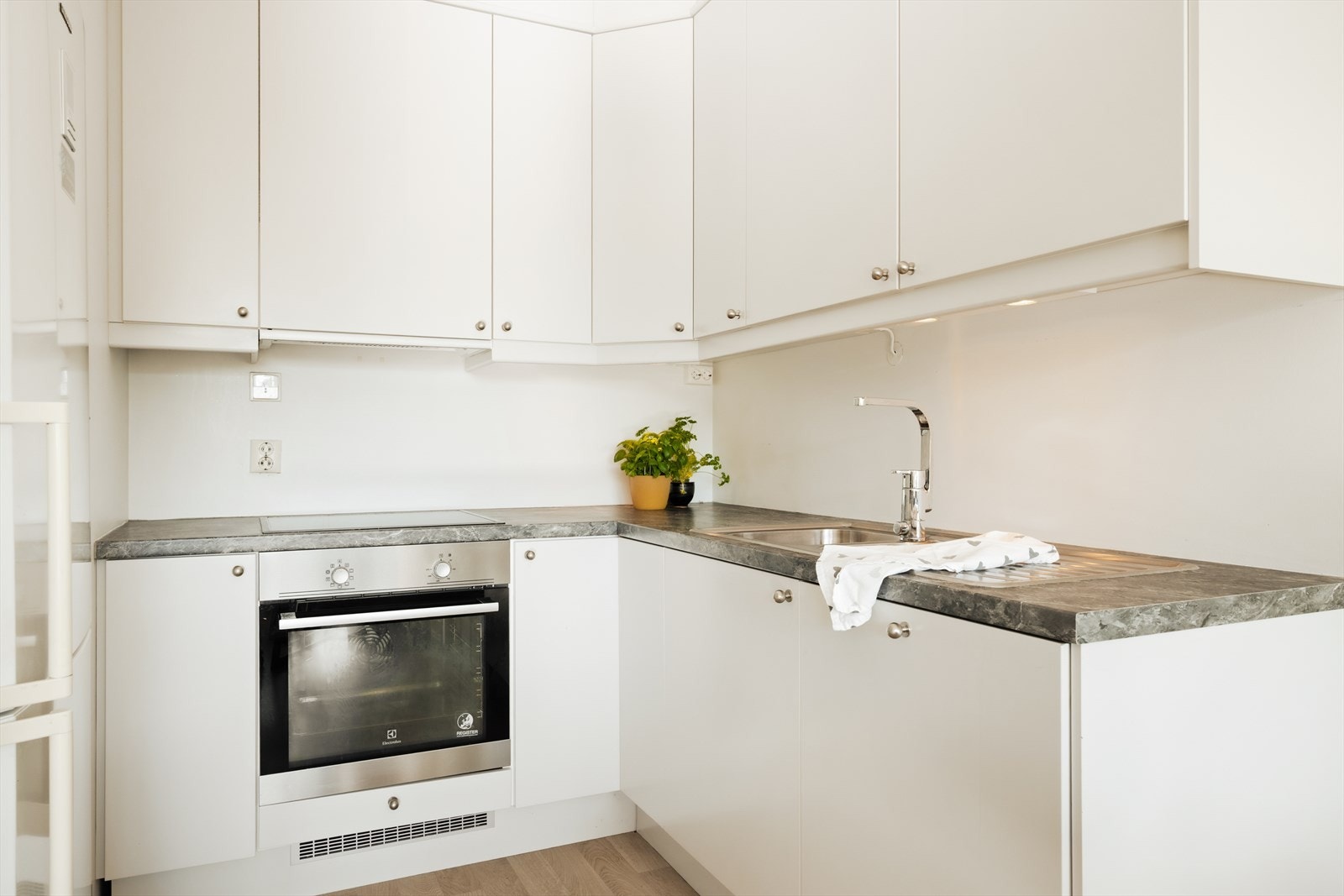 Kjøkkenet er tidløst med slette fronter og integrert platetopp og stekeovn. Galleribilde