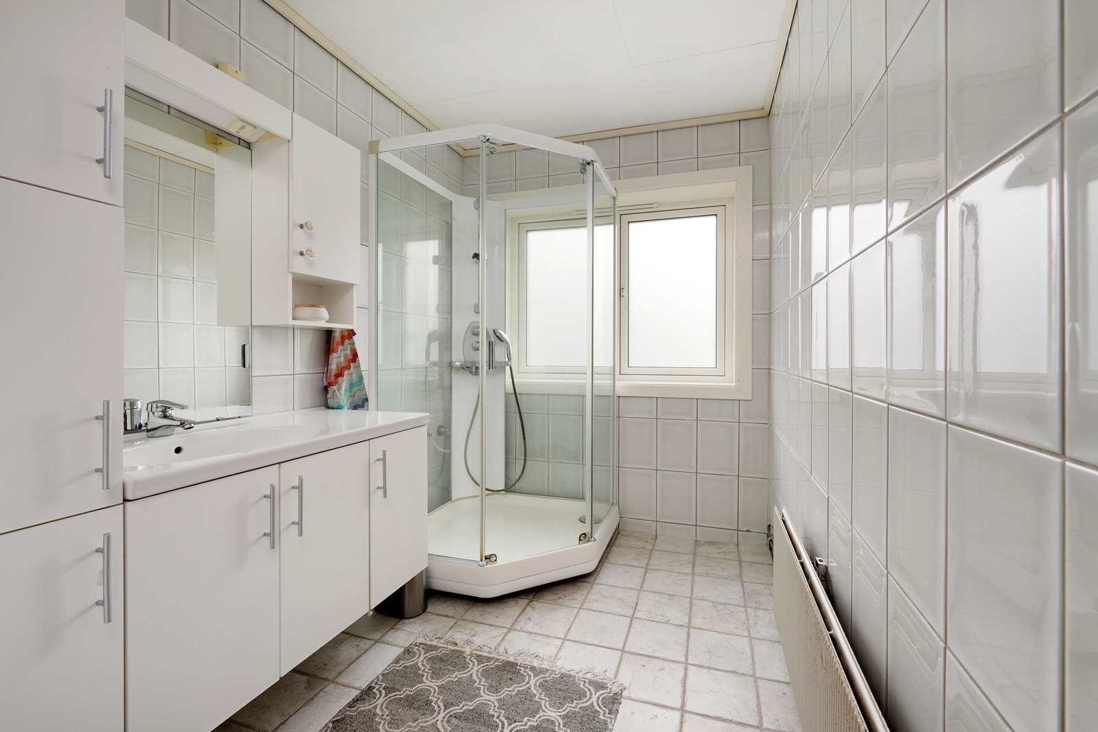 Helfliset bad med dusjkabinett og baderoms-innredning, med opplegg for vaskemaskin og tørketrommel. Oppvarming via radiator som er inkludert i fellesutgiftene. Galleribilde