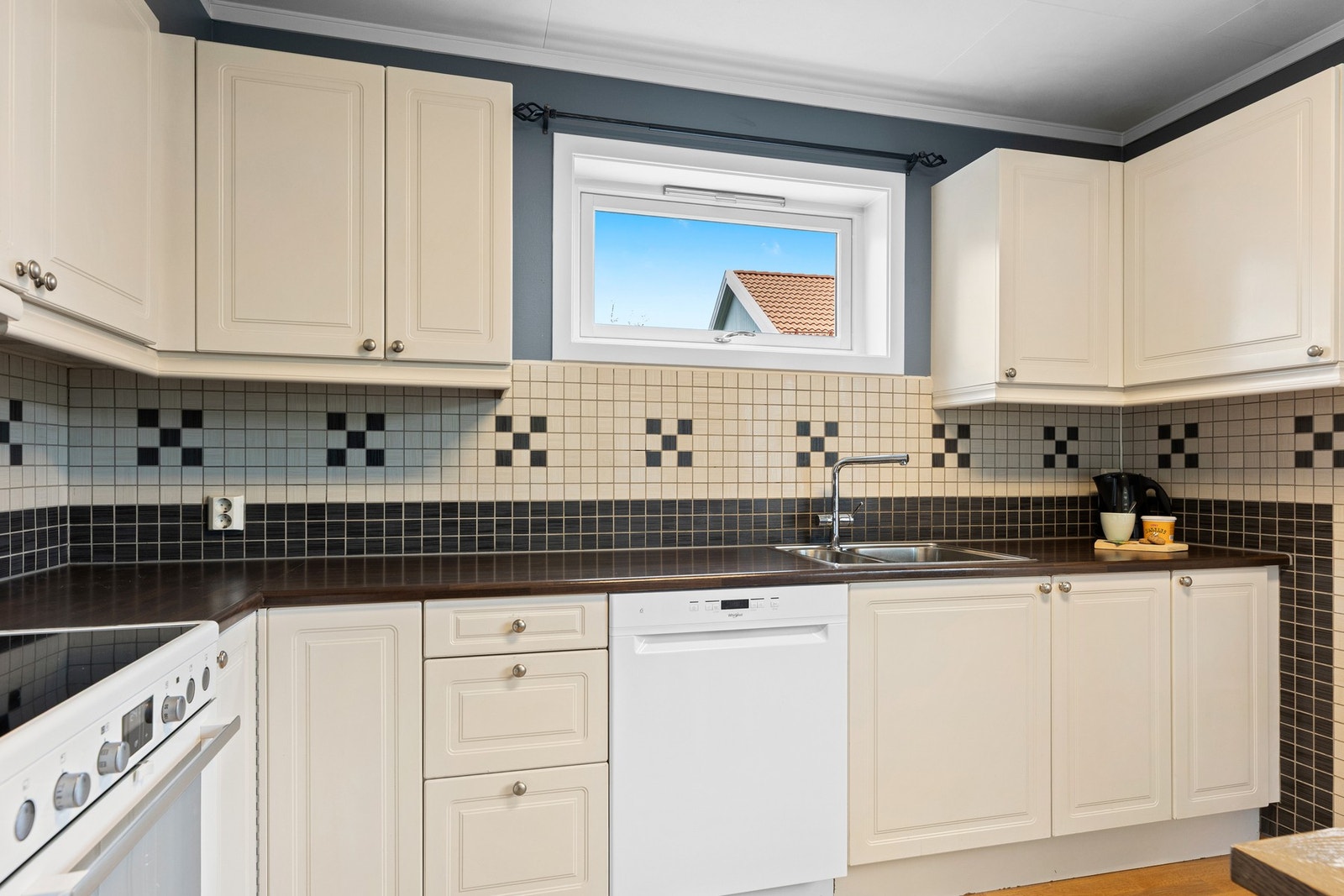 Kjøkken med fliser over benk og laminat benkeplate. Galleribilde