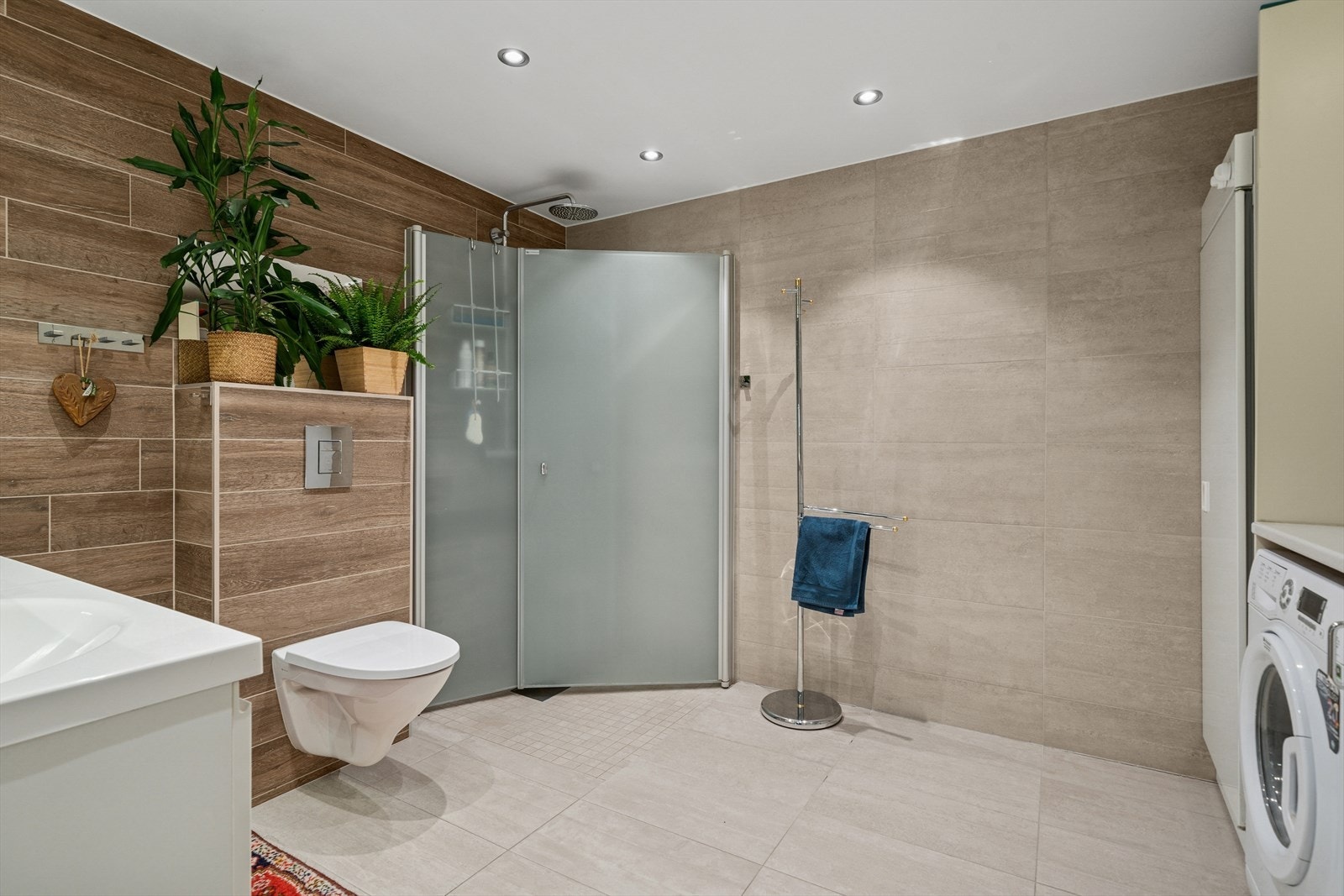 Badet er innredet med servantskap med ett-greps blandebatteri, skap, toalett, dusjhjørne, blandebatteri og dusjgarnityr. Galleribilde