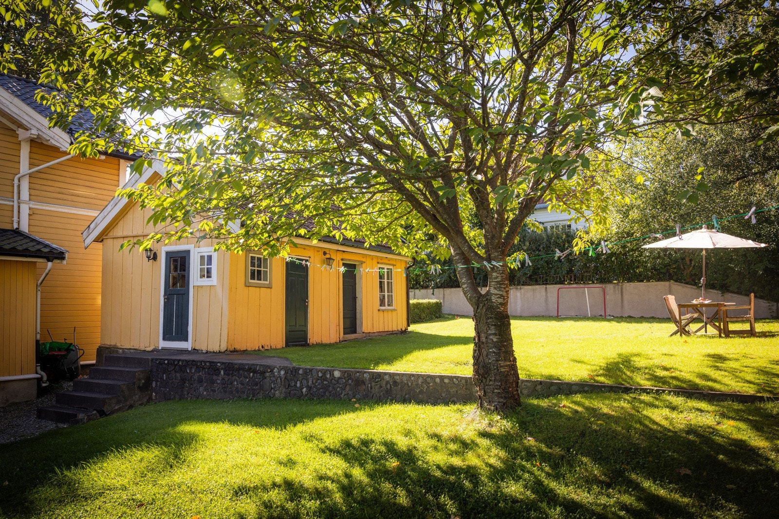 Hagen har flere solrike soner som omkranser huset og er naturlig oppdelt av støttemurer, hekker og trær. Uthuset er oppmålt til 23 kvm. Galleribilde