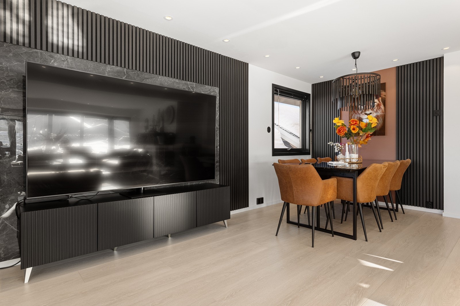 Tv-en er plassert fint inn i en moderne ramme av spilevegg, spilene skaper en moderne kontrast til rommet. Galleribilde