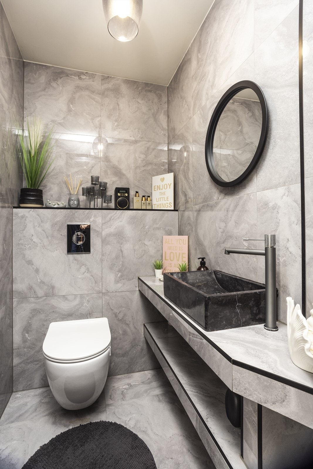 Lekkert gjestetoalett med flislagte overflater, servant med servanttopp og veggehengt toalett. Galleribilde