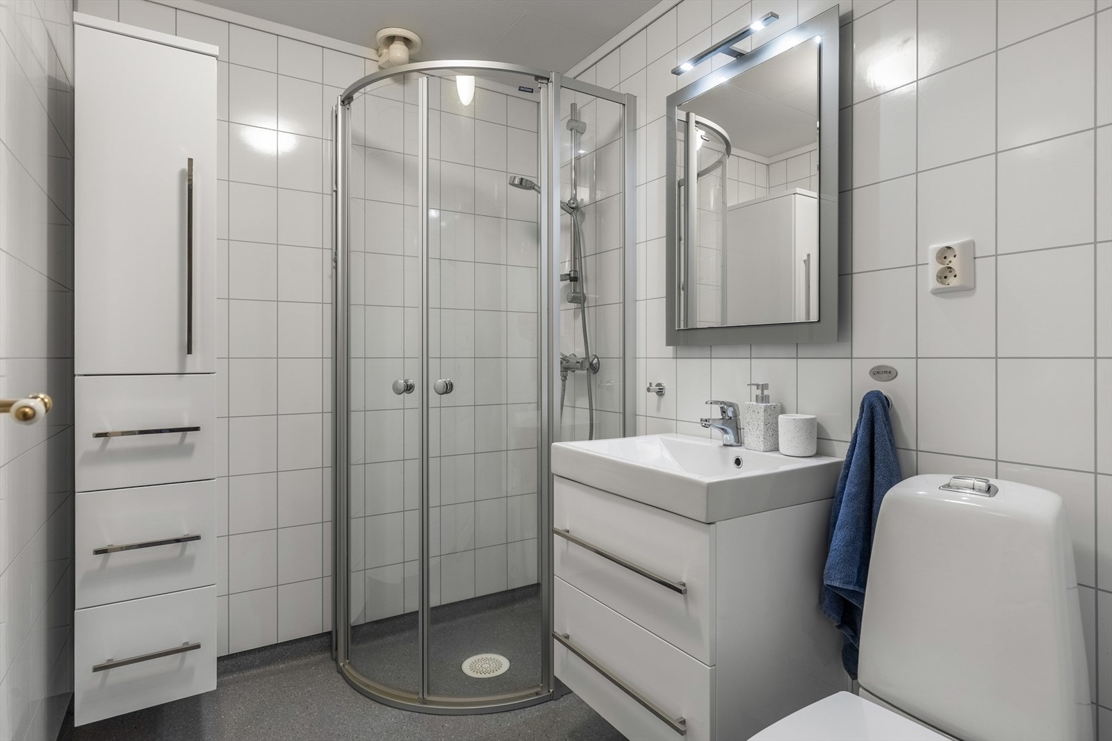 Badet er innredet med servant, dusjhjørne og toalett Galleribilde