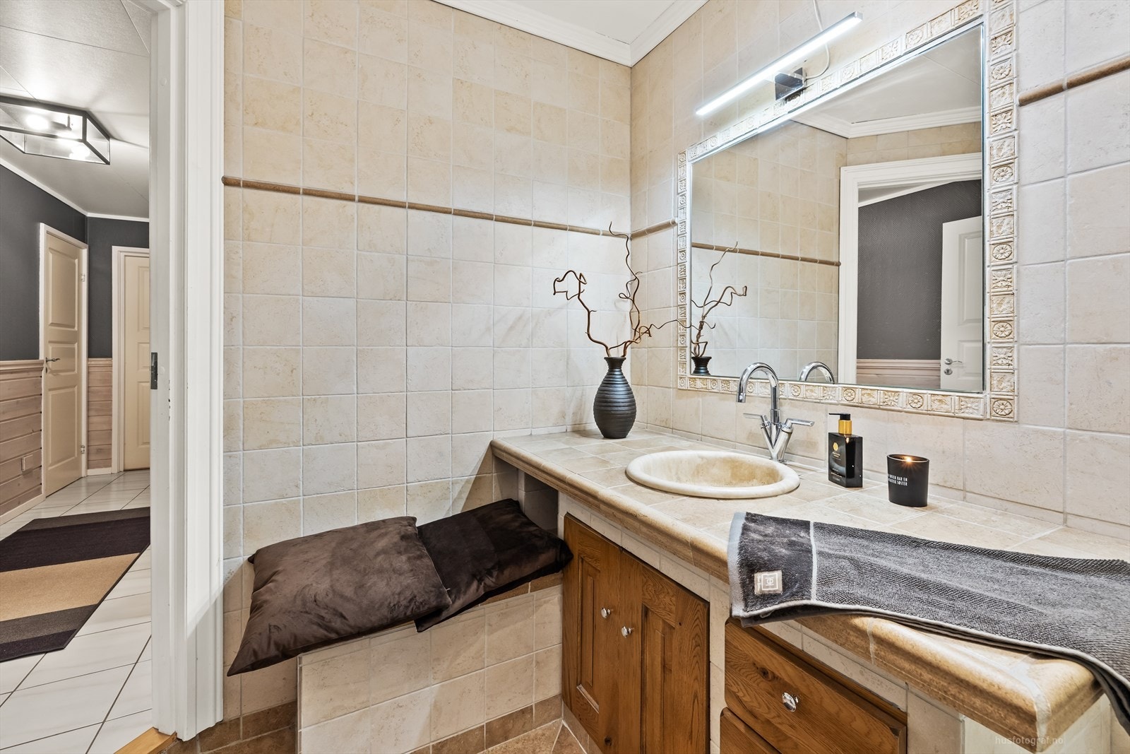 Rommet er innredet med en plassbygd, flissatt servantløsning, vegghengt toalett og et praktisk dusjkabinett. Galleribilde