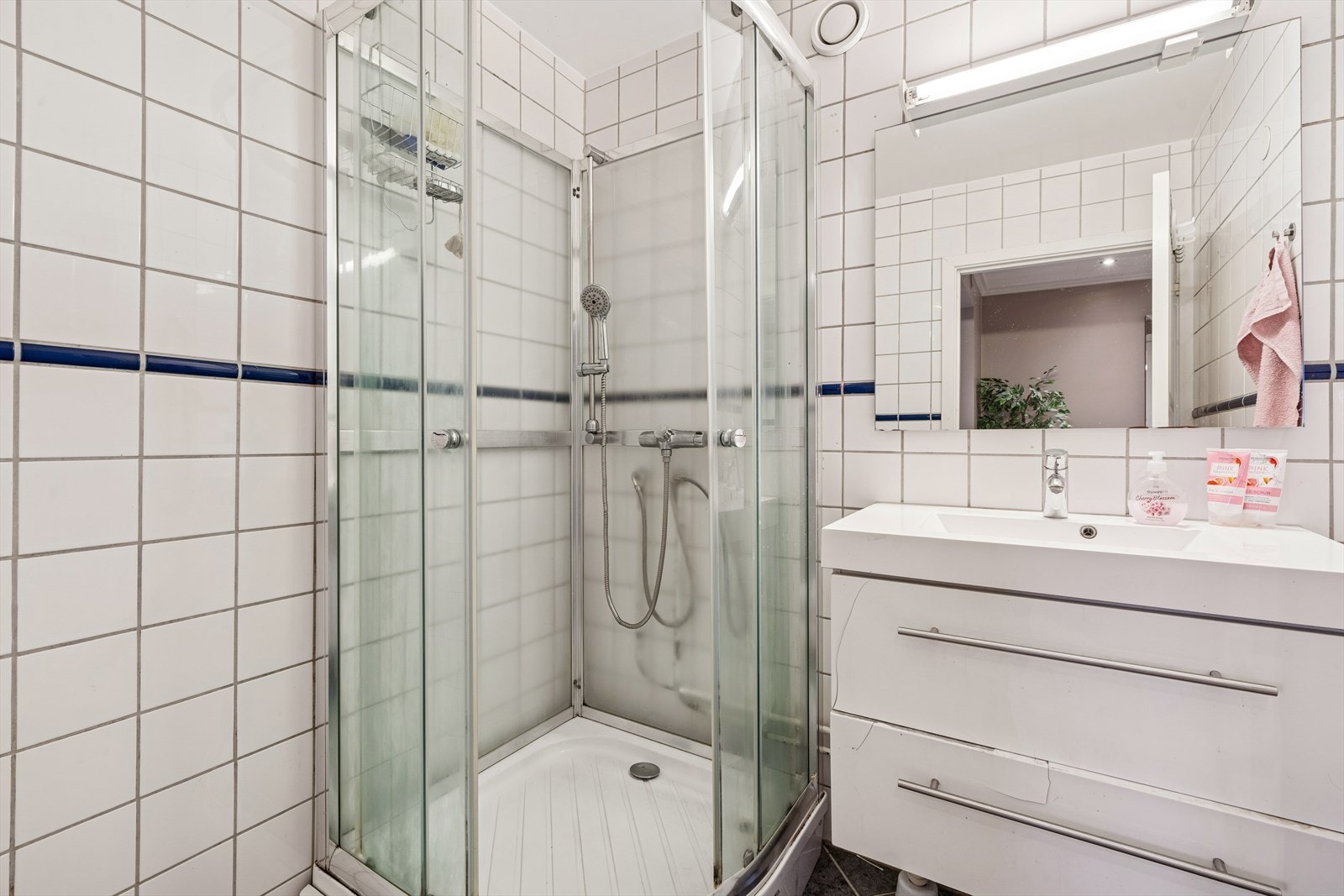 Leiligheten har et eldre bad med fliser på vegger og gulv. Rommet er utstyrt med innredning med nedfelt servant og dusjkabinett. Badet har mekanisk avtrekk. Galleribilde