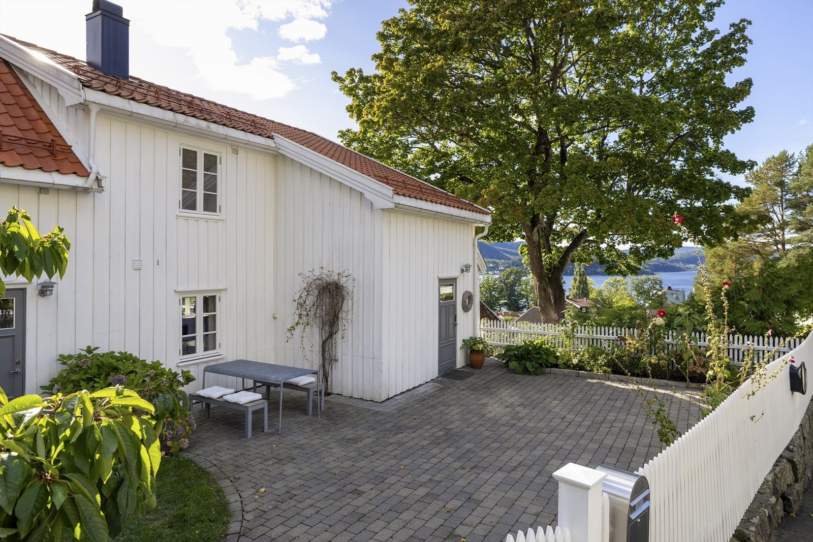 Inngjæret eiendom med elbil-lader montert på stakittgjerdet Galleribilde