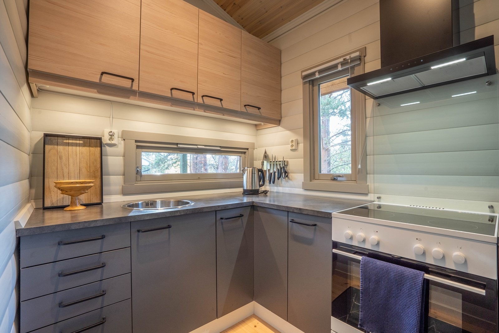 Moderne kjøkken med gode oppbevaringsløsninger og stilrent design. Gråvann ut fra kjøkken under hytta. Galleribilde