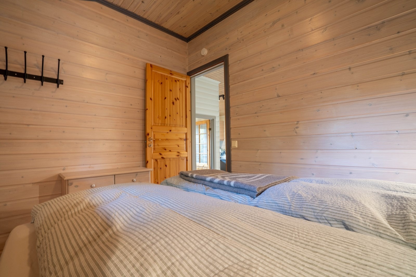 Koselig soverom med trepanel sett inn til kjøkkenet. Perfekt for avslapning i hyttas lune atmosfære. Galleribilde