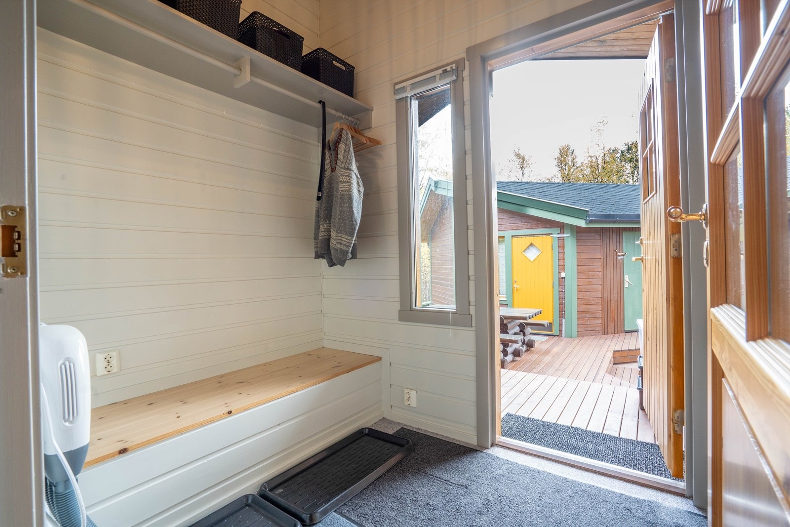 Lyst og innbydende inngangsparti med praktisk garderobeløsning. Direkte utgang til koselig terrasseområde med fargerike detaljer. Perfekt for avslapning. Galleribilde