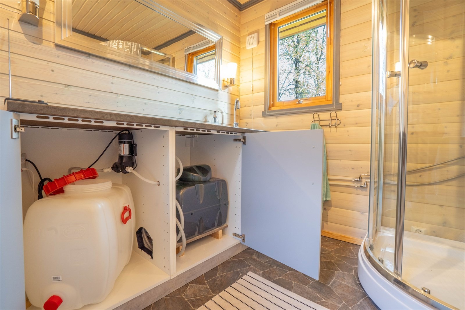 Under benk ser du vanndunk som fylles med medbrakt vann, vannpumpe og varmtvannstank. Galleribilde
