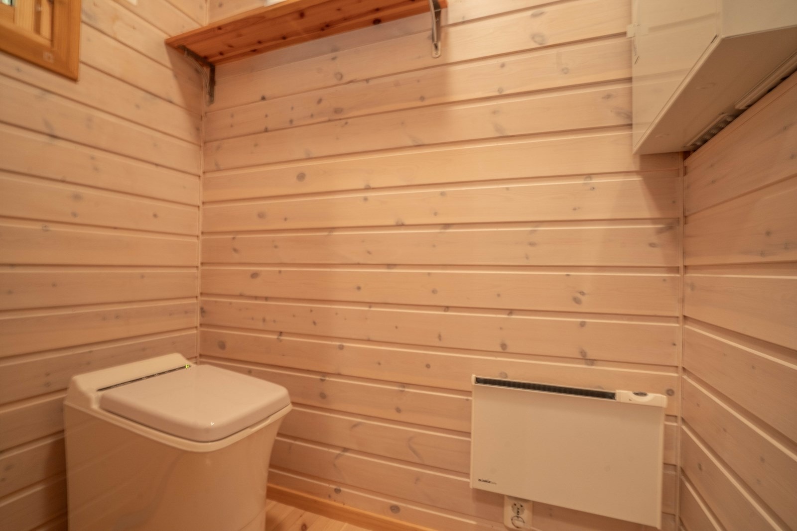 Lyst, moderne toalettrom med panelvegger og strømeffektiv varmeovn. Perfekt for en hytte. Galleribilde