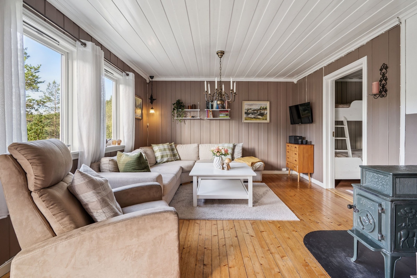 Lun stue med vedovn- et naturlig samlingspunkt etter en dag ute Galleribilde