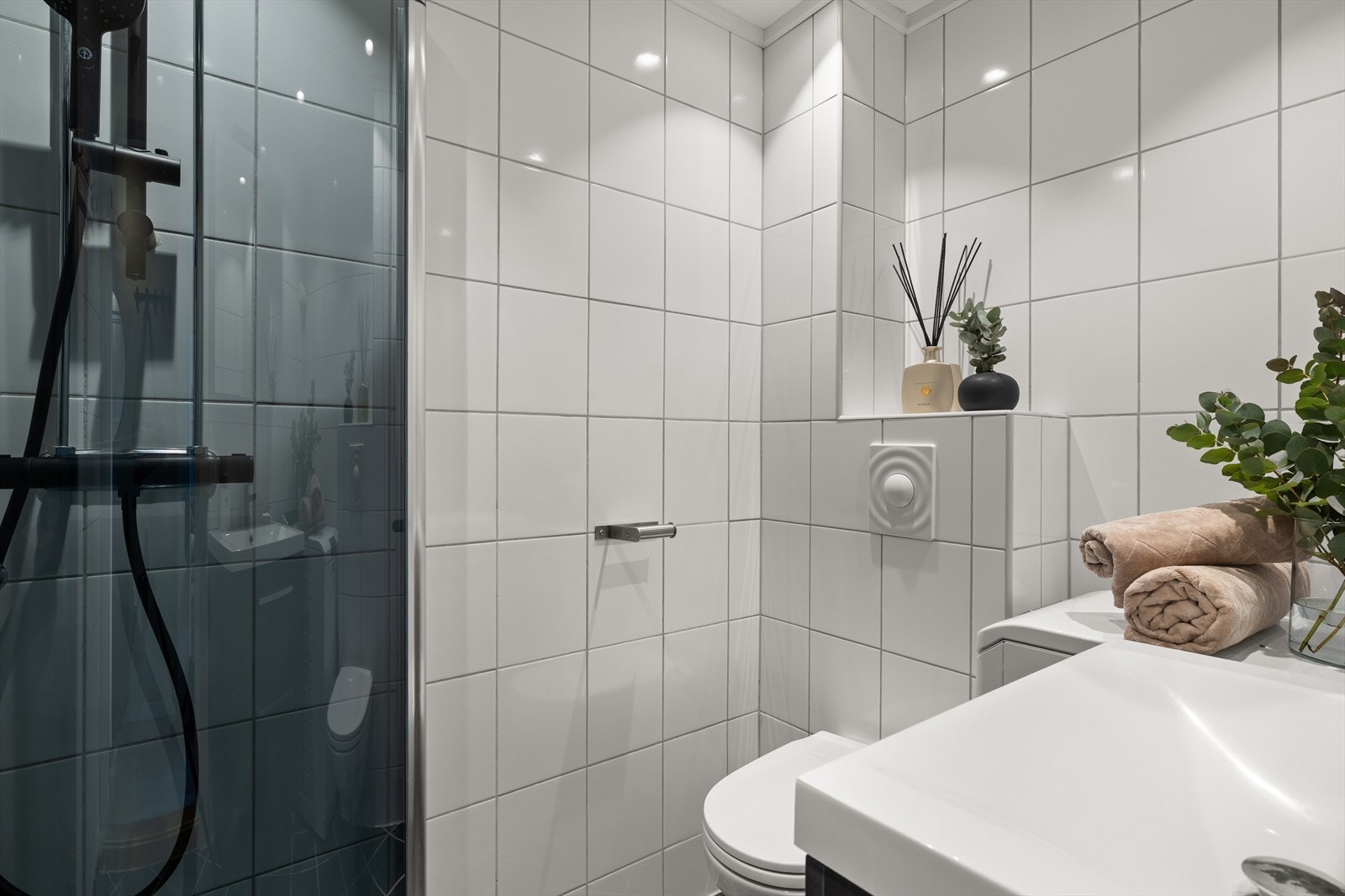 Badet har varmekabler i gulv, dushjørne med innfellbare dusjdører, servant med innredning, toalett og opplegg for vaskemaskin. Galleribilde