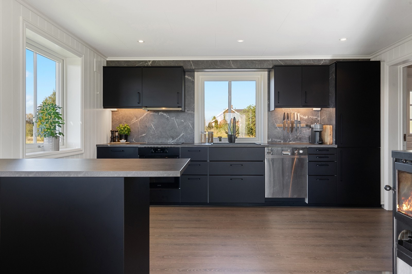 Kjøkken med svarte glatte fronter og integrerte hvitevarer Galleribilde