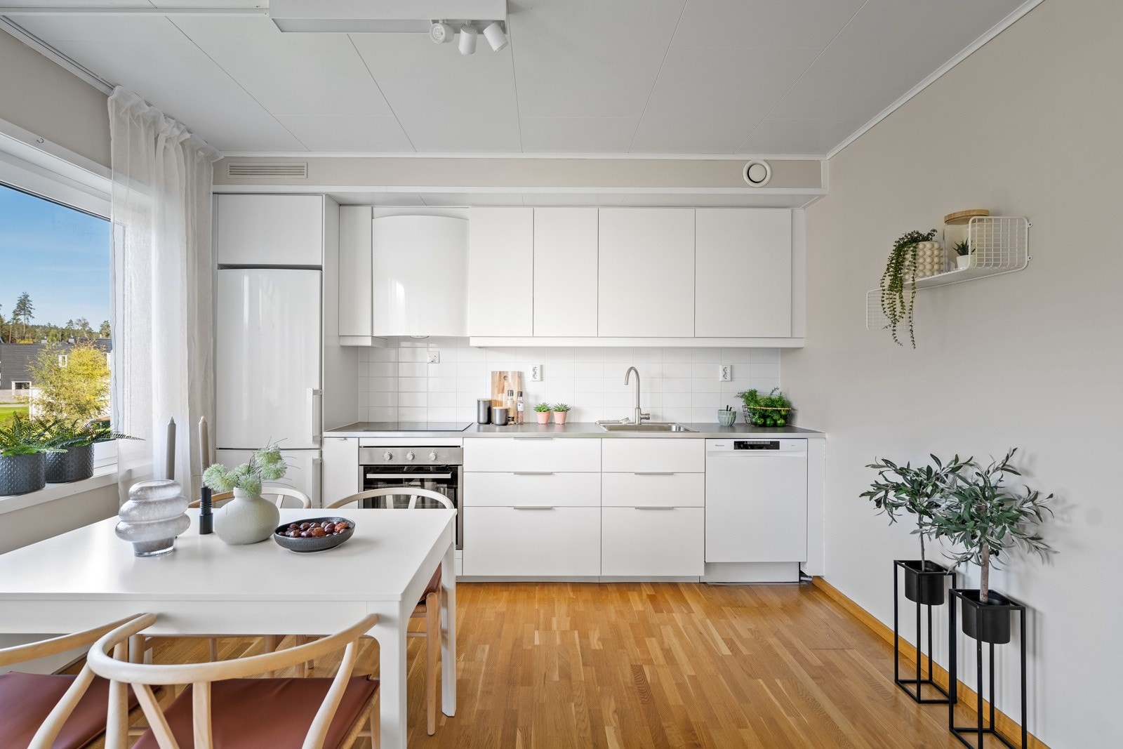 Kjøkkeninnredningen har hvite, glatte fronter, laminat benkeplate med nedfelt kum i rustfritt stål, samt integrert induksjonstopp og stekeovn. Opplegg for oppvaskmaskin og avsatt plass til kjøl/frys. Galleribilde