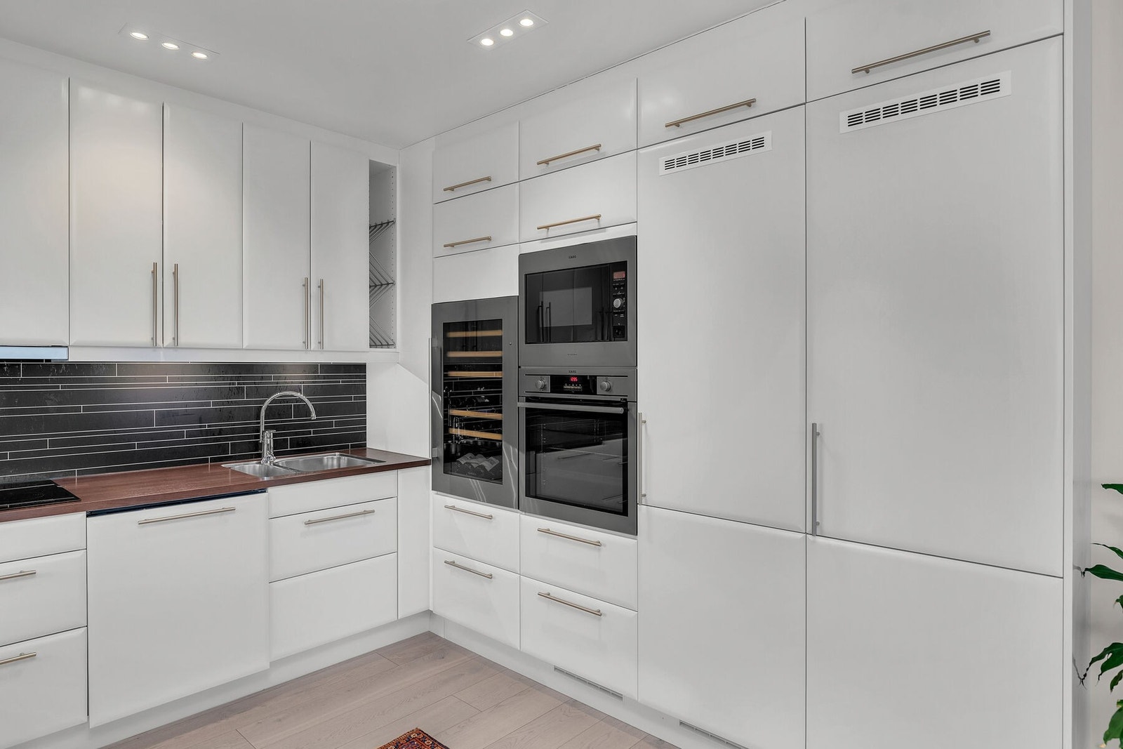 Kjøkkenet har innredning med glatte fronter, laminat benkeplate og integrerte hvitevarer. Galleribilde