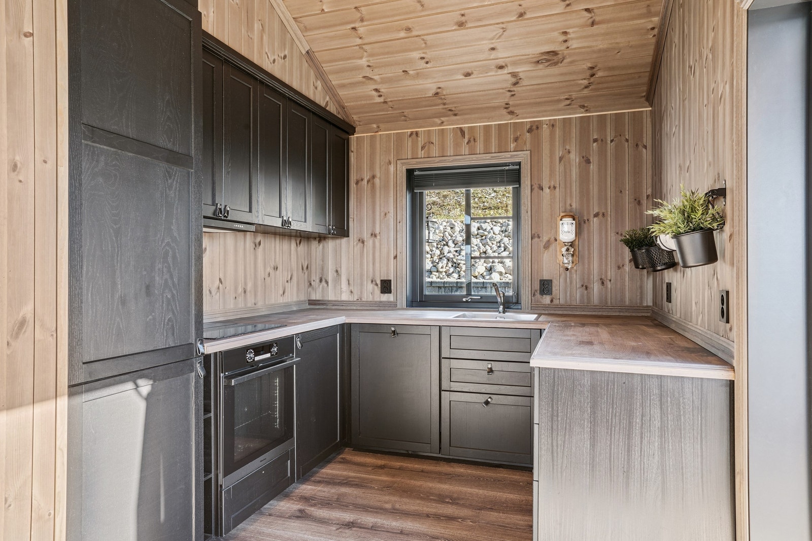 Kjøkkenet har en praktisk hjørneløsning med innredning med speilfronter og benkeplate i tre. Galleribilde