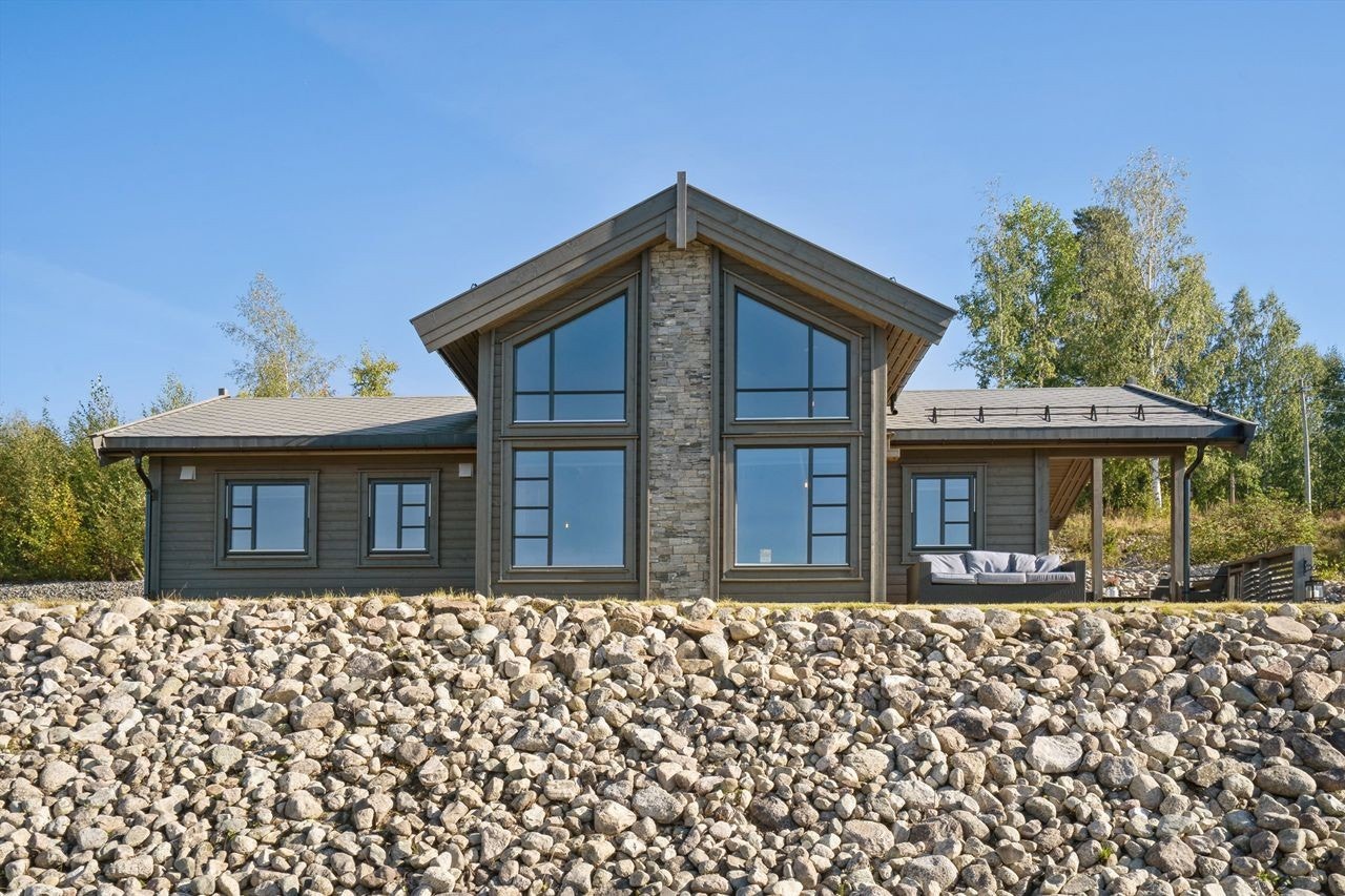 En moderne fritidsbolig fra 2022, med en fasade som kombinerer liggende trekledning og skifer. Galleribilde