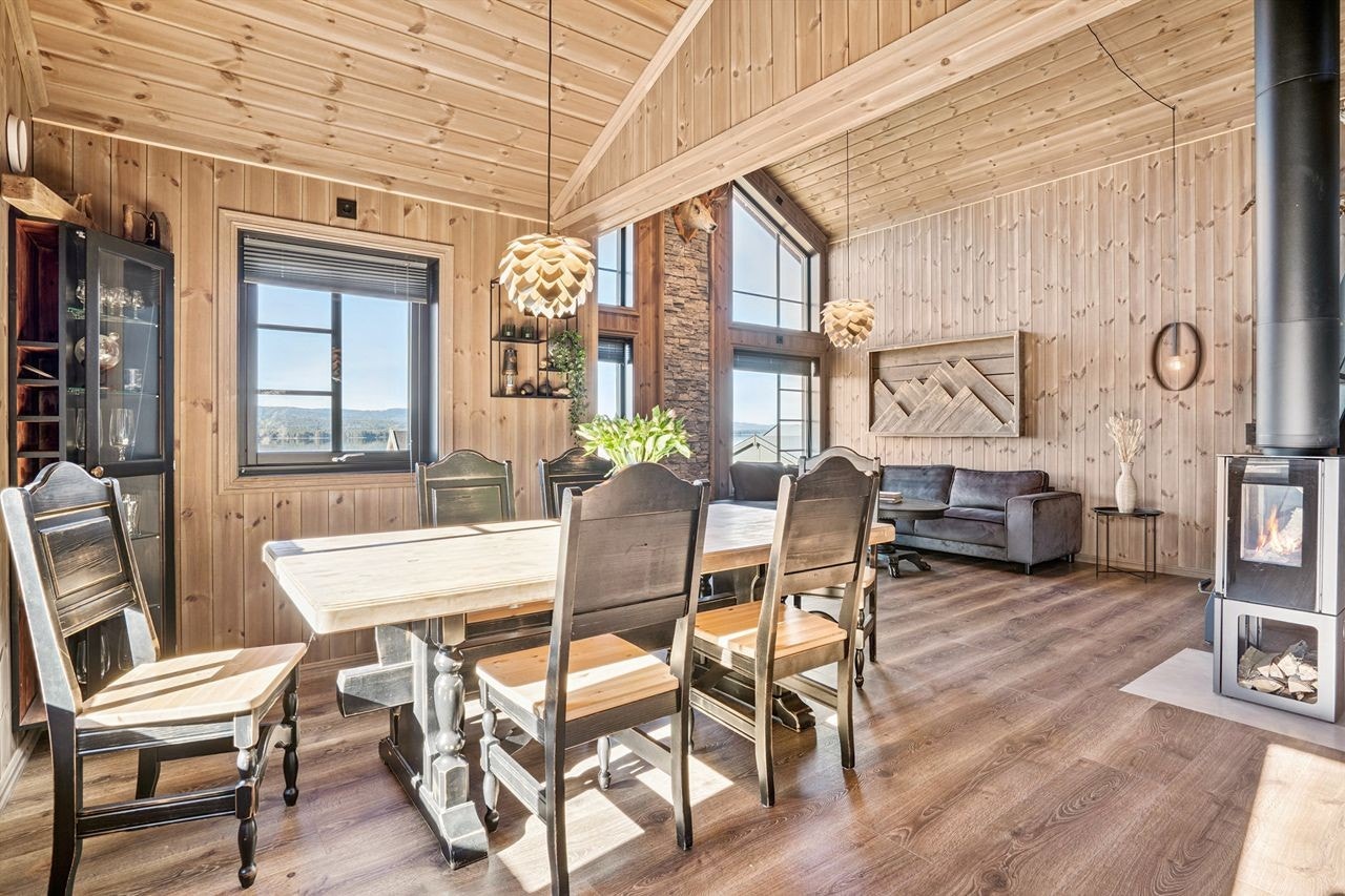 I åpen løsning med stuen ligger spisestuen, med en moderne vedovn som gir ekstra varme. Galleribilde