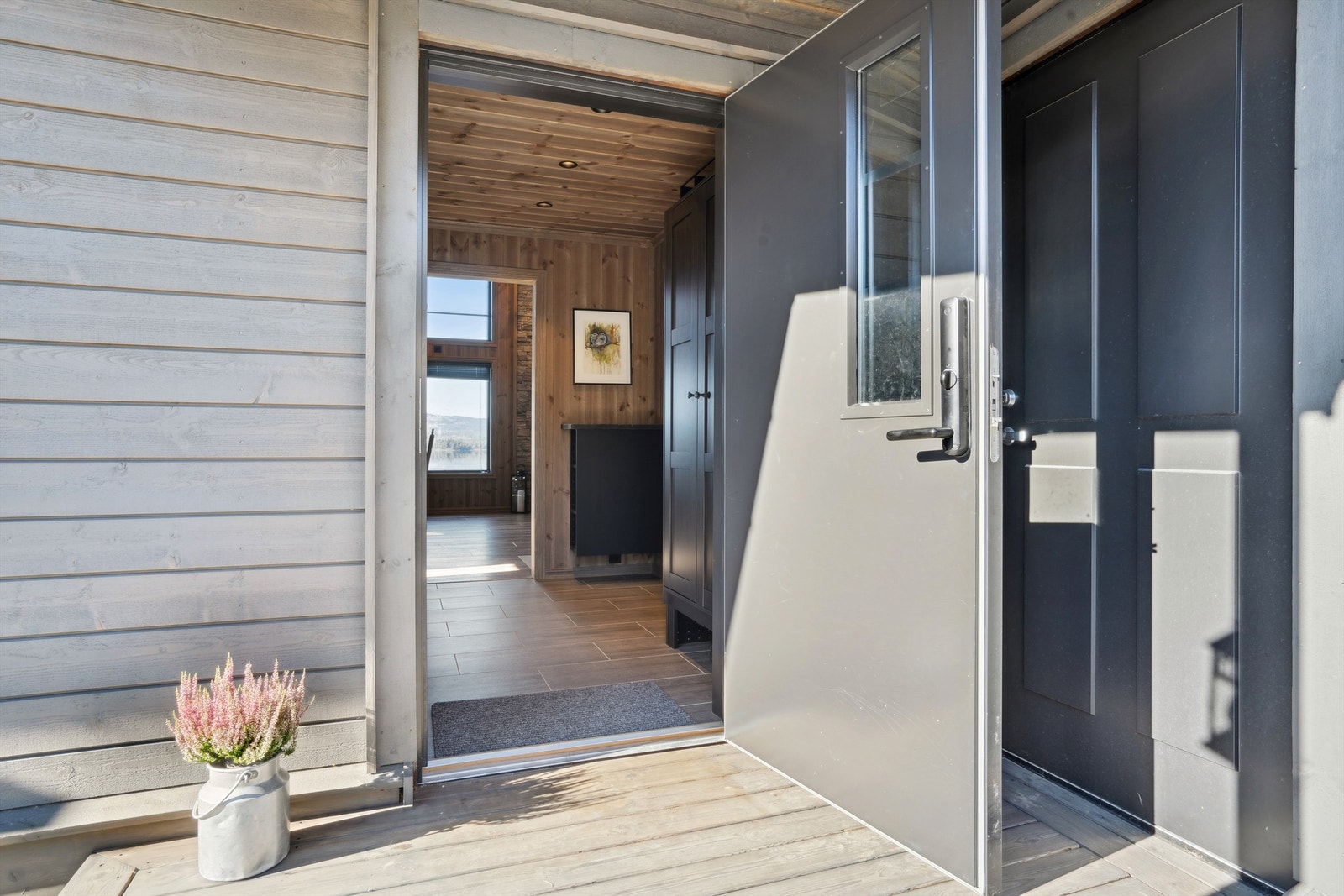 Velkommen inn i en lys entré med flislagt gulv og downlights i himlingen. Galleribilde