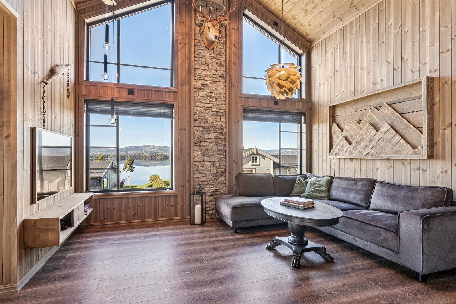 Stuen har en imponerende takhøyde og store vindusflater fra 2022 som gir rikelig med lys. Galleribilde