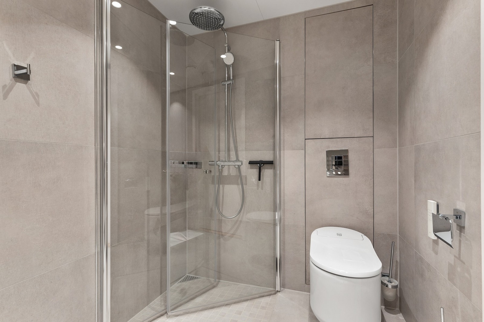 Badet er innredet med bl.a. dusjhjørne, toalett og servant med tilhørende skap Galleribilde