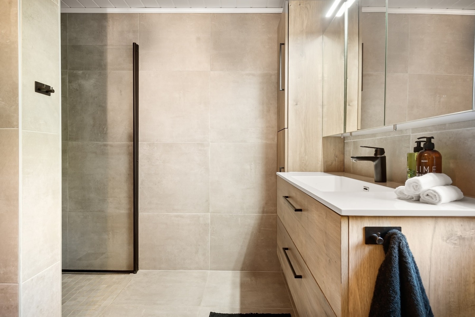 Her er det 60x60 fliser, vegghengt toalett, baderomsinnredning med vask og dusjhjørne. Det er også etablert mulighet for badekar Galleribilde