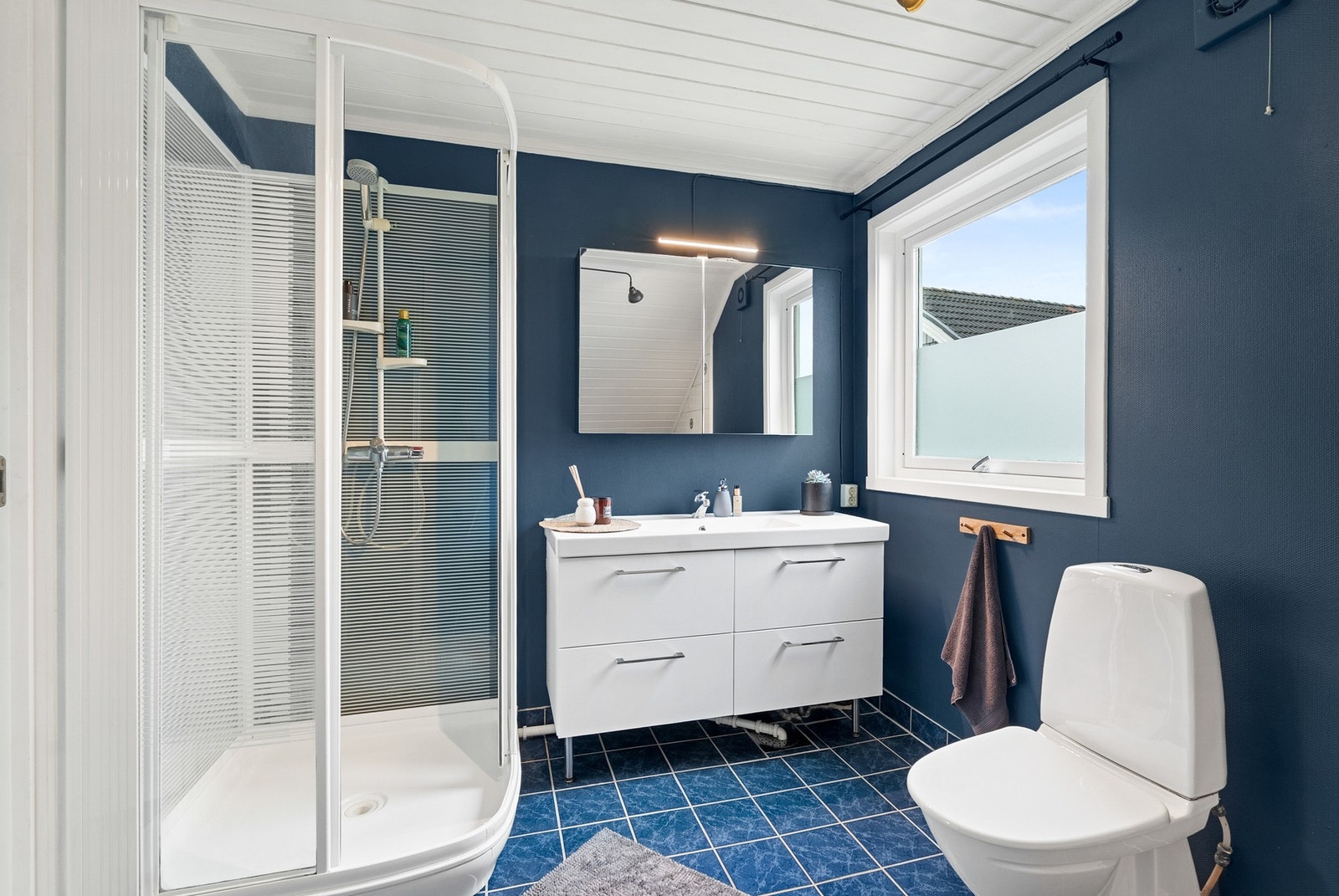 Innredning med nedfelt servant, toalett, dusjkabinett og badekar. Galleribilde