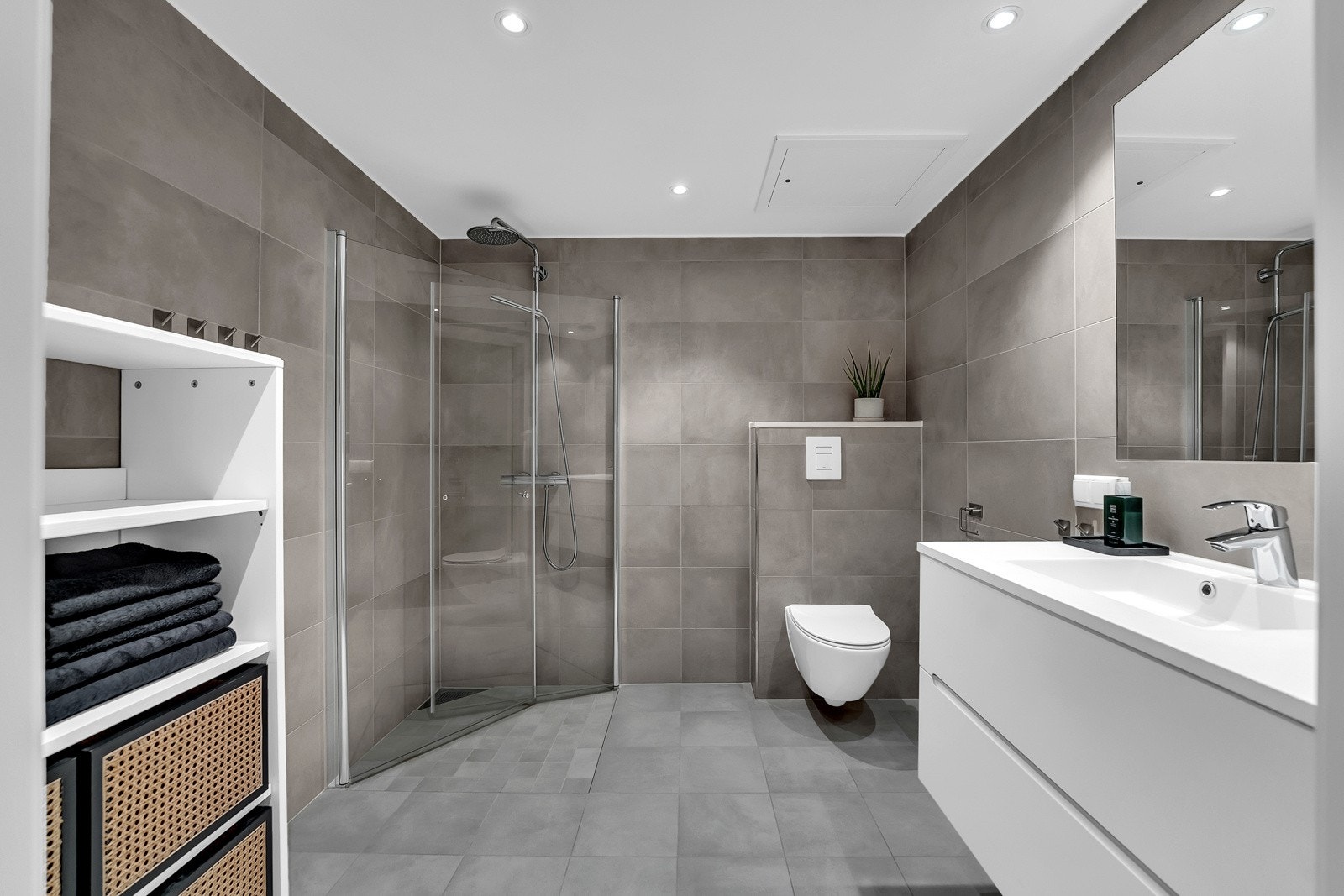 Lekkert flislagt bad med gulvvarme, dusj, toalett og baderomsinnredning. Galleribilde