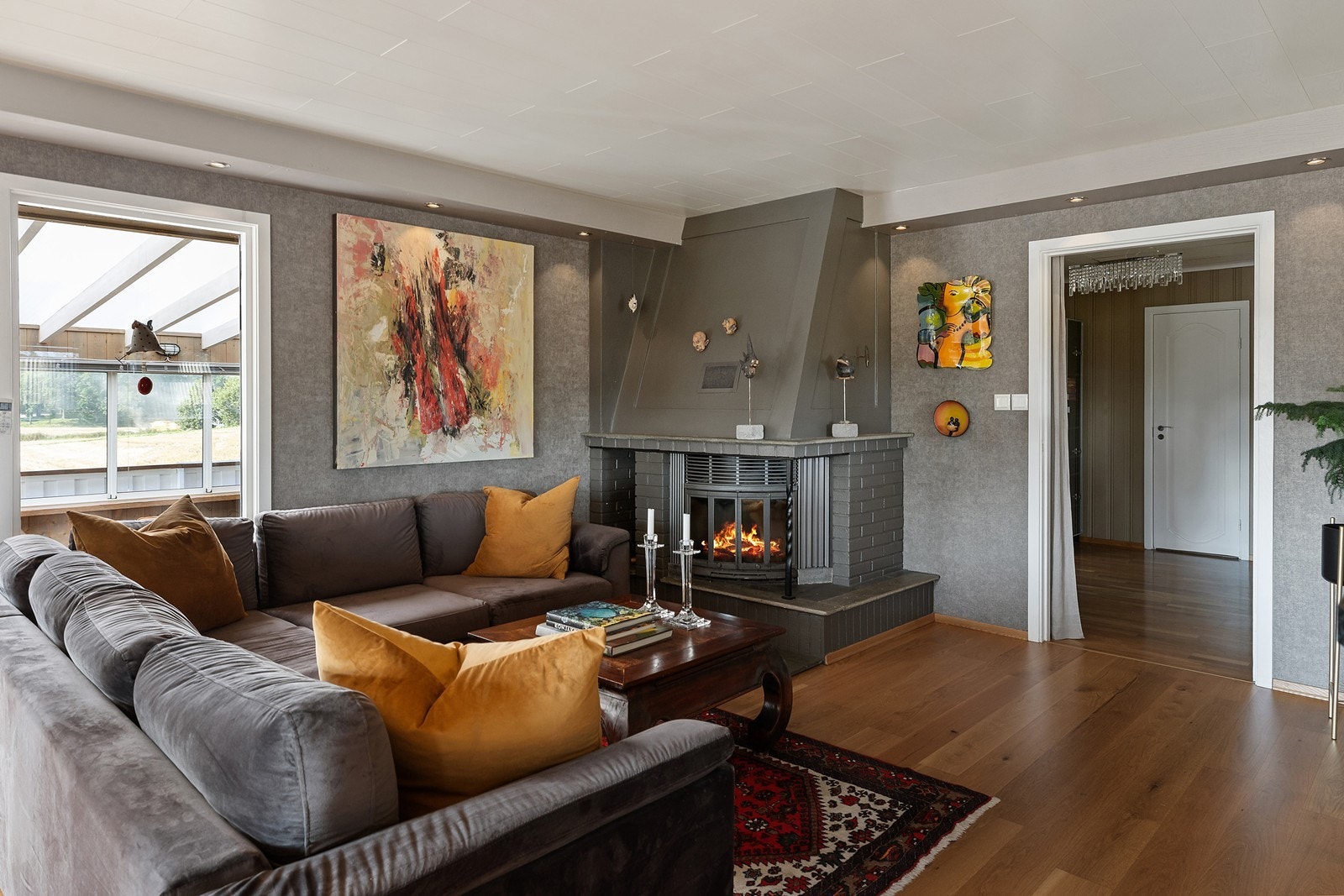 Hyggelig del av stuen, med fyr i peisen en sen høstkveld Galleribilde