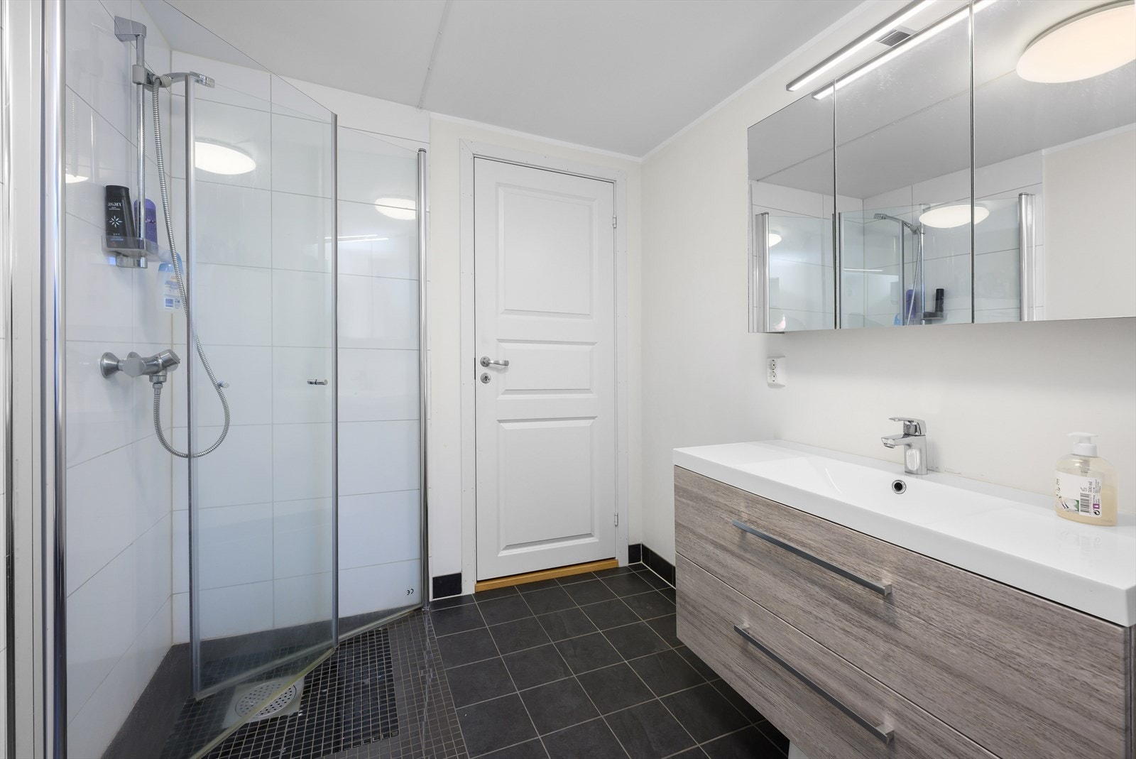 Badet er utstyrt med dusjhjørne, servant, toalett og opplegg til vaskemaskin. Galleribilde