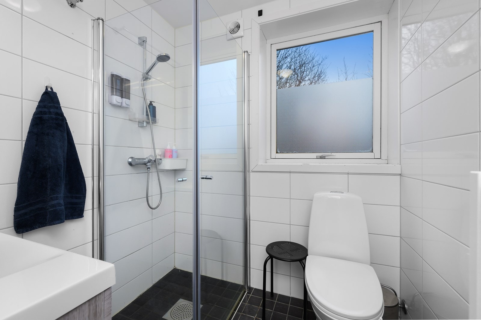 Badet er utstyrt med toalett, servant og dusjhjørne. Galleribilde