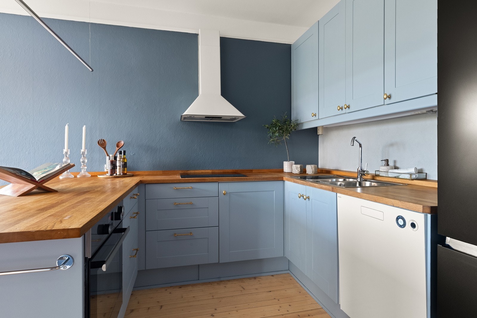 Løsningen kombinerer integrerte hvitevarer som stekeovn og induksjonstopp med frittstående kjøleskap, fryser og oppvaskmaskin. Galleribilde