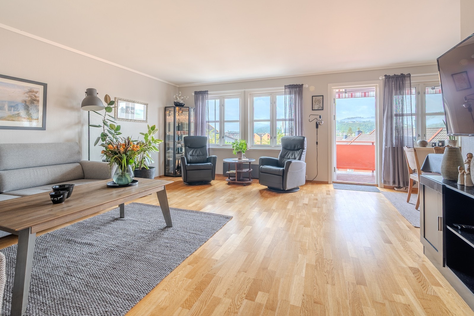 Sosialt allrom med store, sydvest-vendte vinduer og utgang til balkong Galleribilde