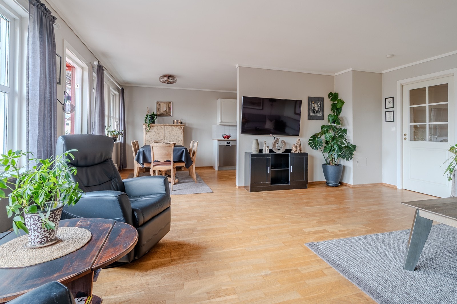 Stuen ligger i åpen løsning med kjøkkenet, og sammen danner de et luftig og innbydende allrom Galleribilde