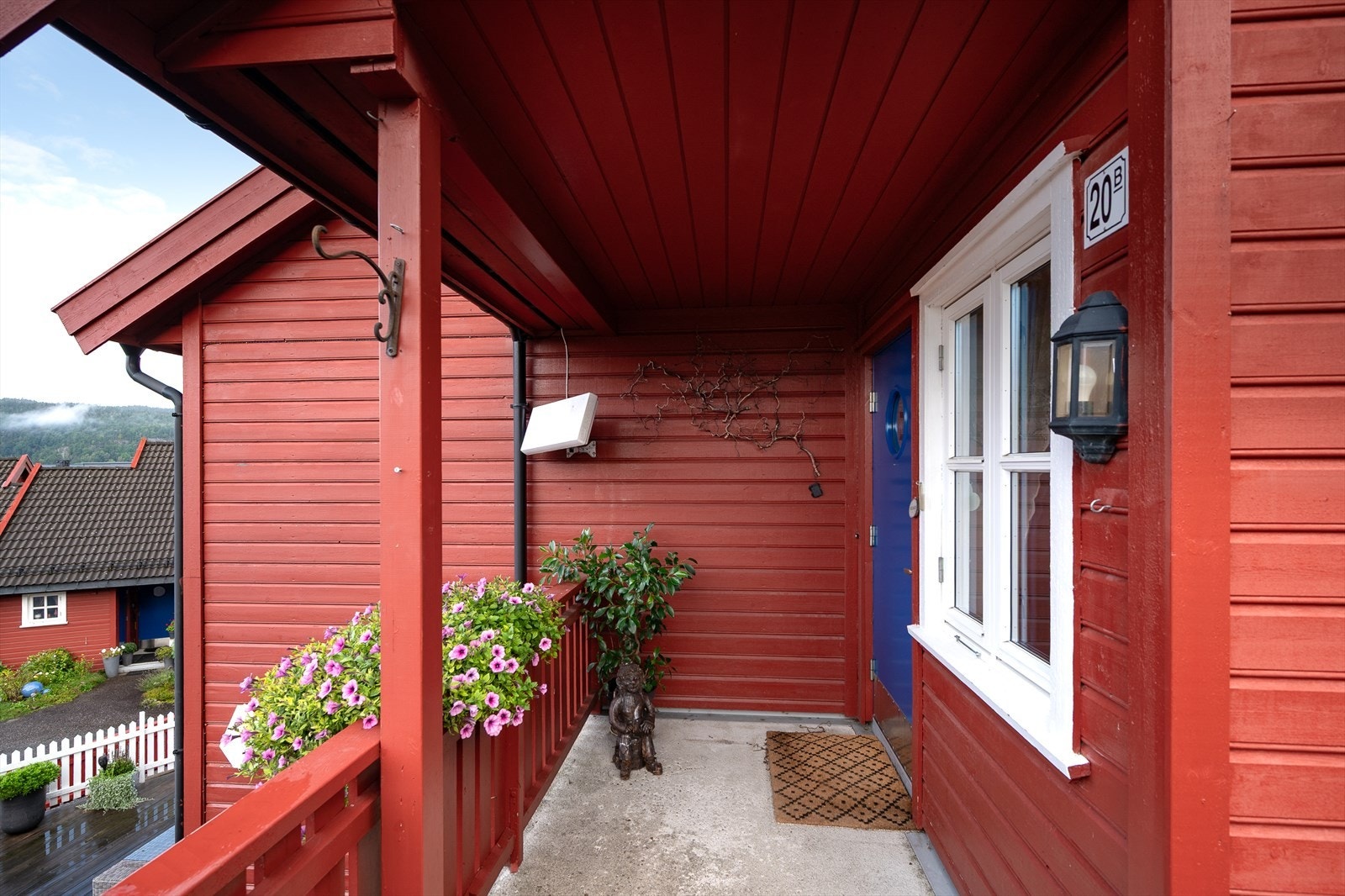 Overbygd inngangsparti med støpt repos og veggmontert utebelysning Galleribilde