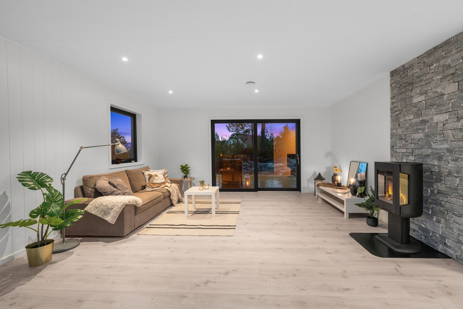 Hele rommet fylles med dagslys fra vinduer på tre sider - den ene siden i form av en dobbel skyvedør med glass helt ned Galleribilde