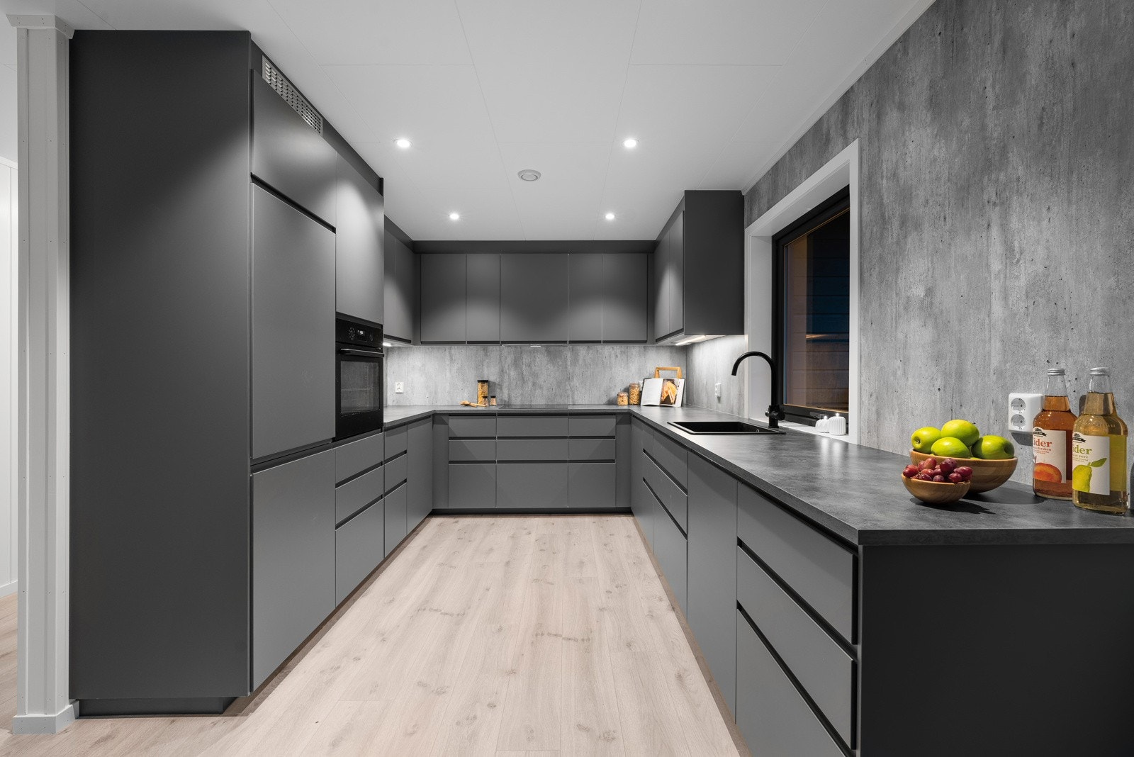 Lekker kjøkkeninnredning med takhøye skal fra Ikea er hesteskoformet, og har slette, mørkegrå, fronter Galleribilde