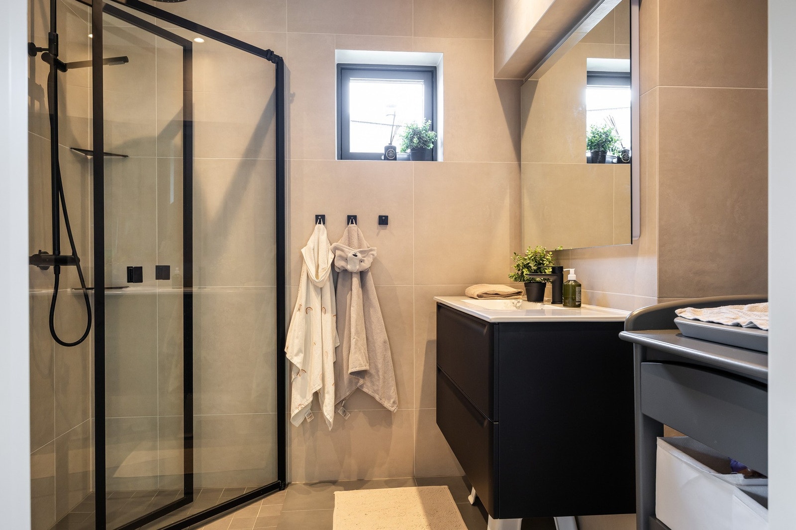 Badene i boligen fremstår moderne og delikate, og det er opplegg for vaskemaskin både i 1. etasje og underetasje. Galleribilde