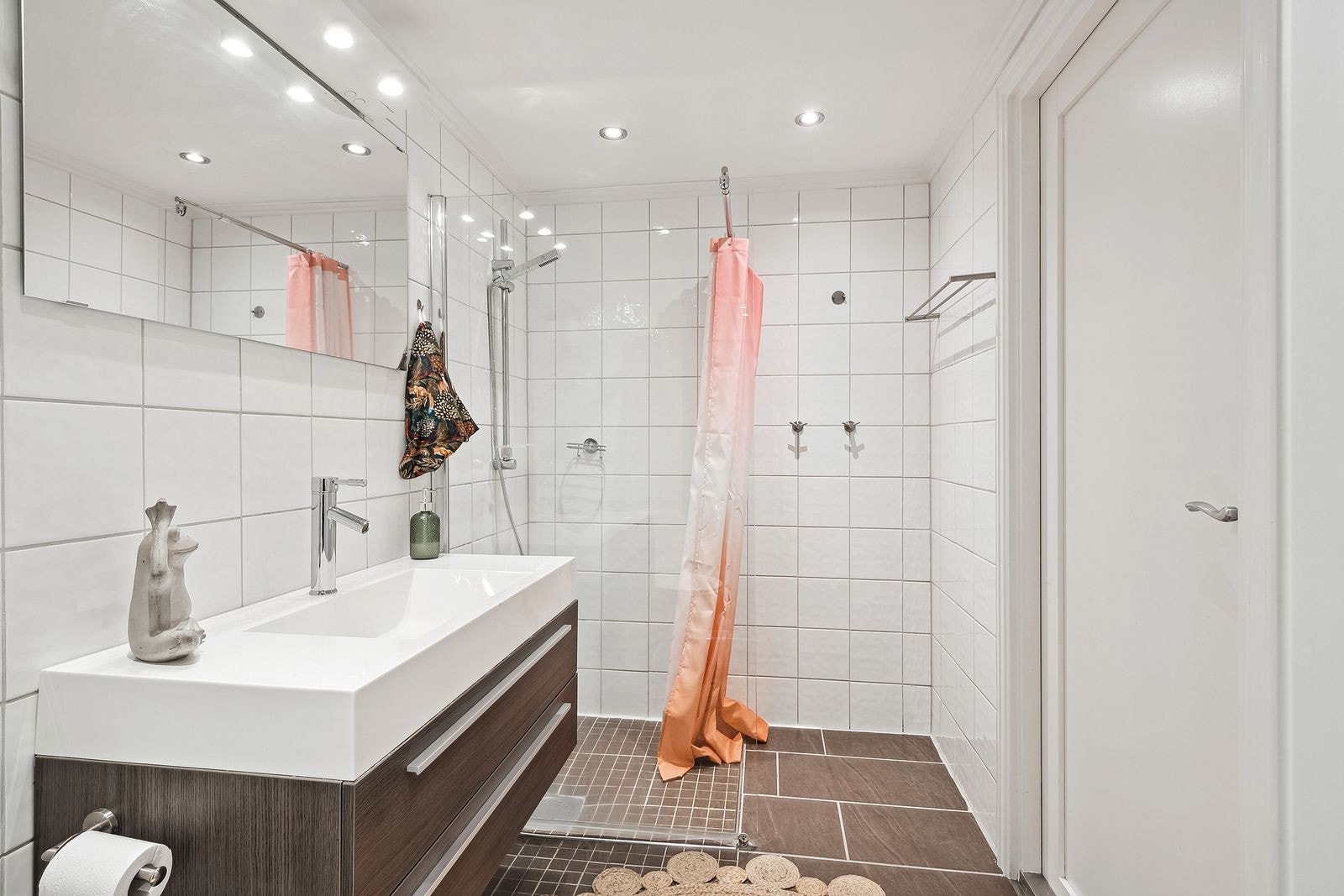 Pent flislagt bad med toalett, dusjsone og servant m/innredning. Galleribilde