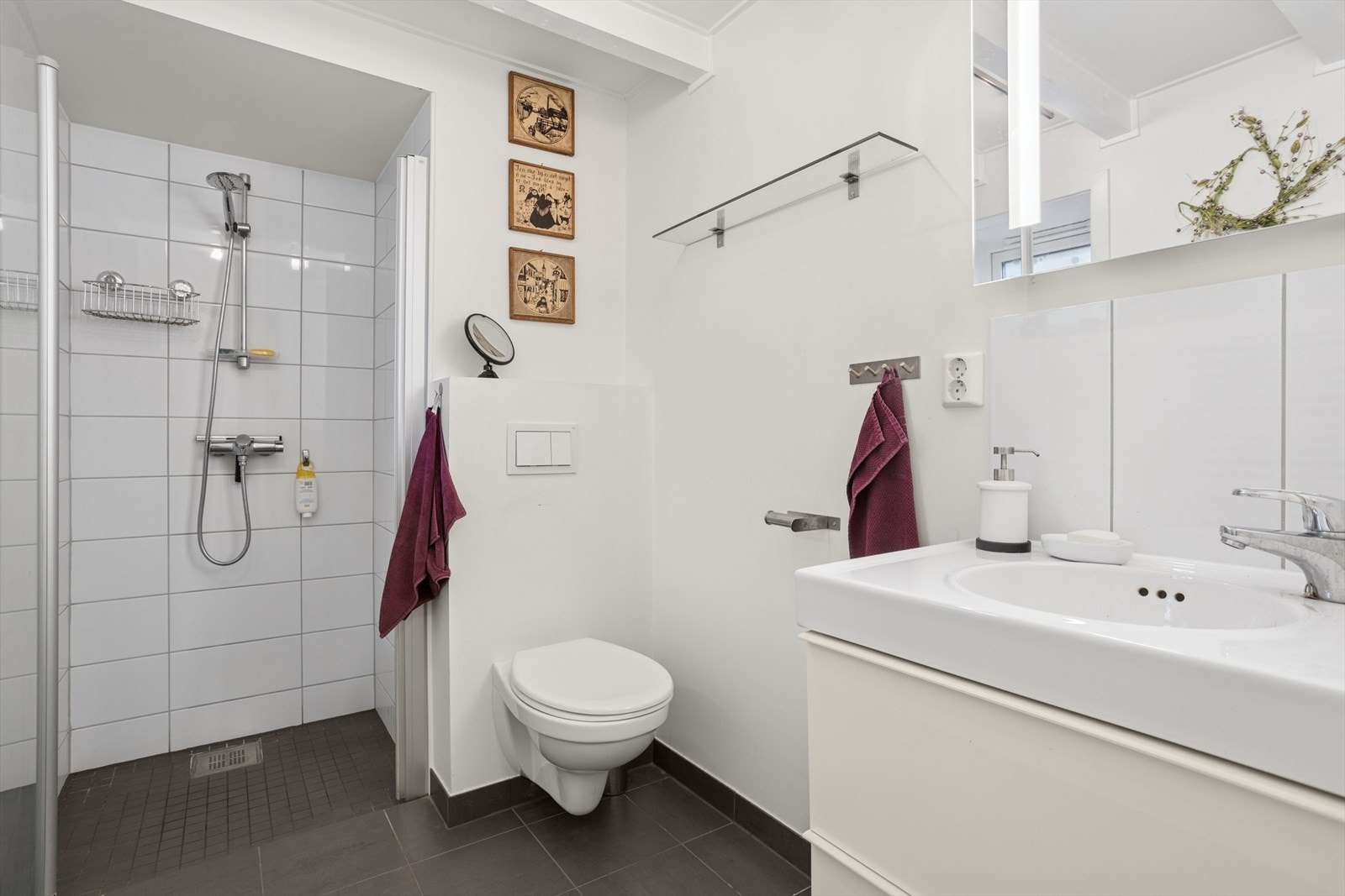 Baderom i underetasjen med fliselagt gulv med varmekabler og innredning med vegghengt toalett, dusjnisje og servant med skuffer. Galleribilde