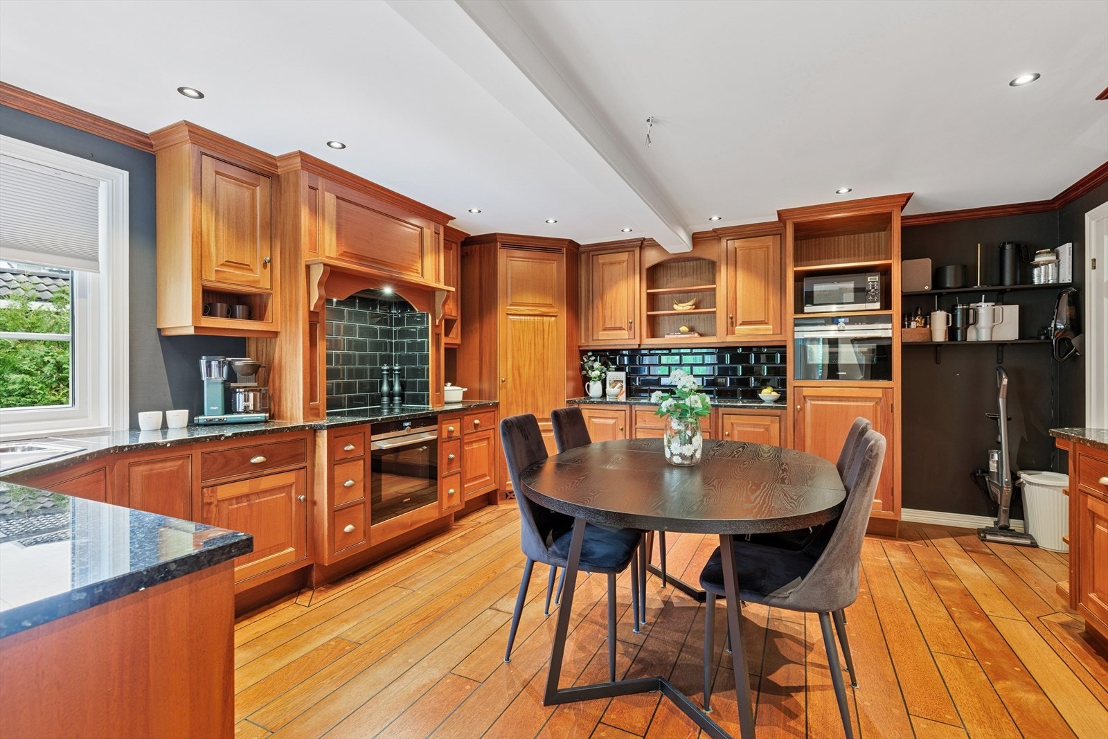 Stort kjøkken med rikelig skap- og benkeplass. Benkeplate av stein og integrerte hvitevarer. Galleribilde