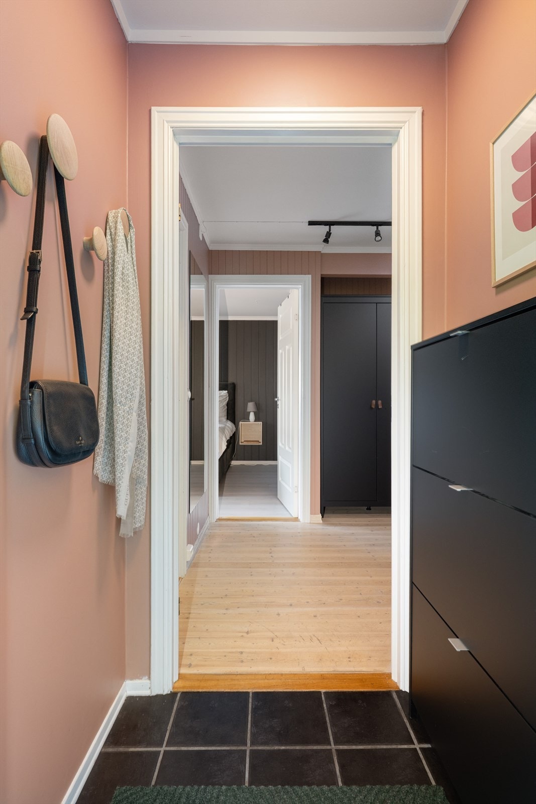 Fin, liten entré med flislagt gulv og plass til skoskap, samt mulighet for å henge fra seg yttertøy. Malte veggflater og malt tak. Galleribilde