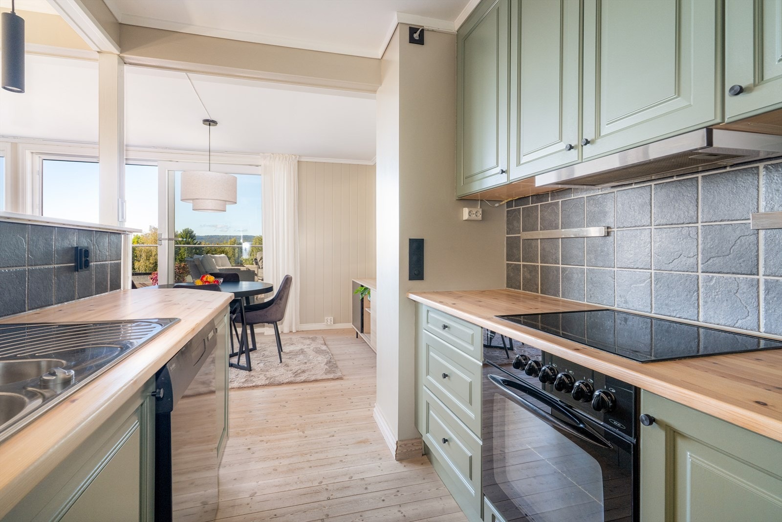 Flis på vegg over heltre benkeplate med gode arbeidsflater, nedfelt platetopp og nedfelt benkebeslag i rustfritt stål. Galleribilde