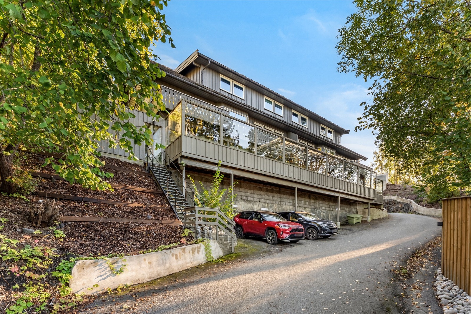 Fasadebilde av bygget med biloppstillingsplasser rett utenfor. Galleribilde