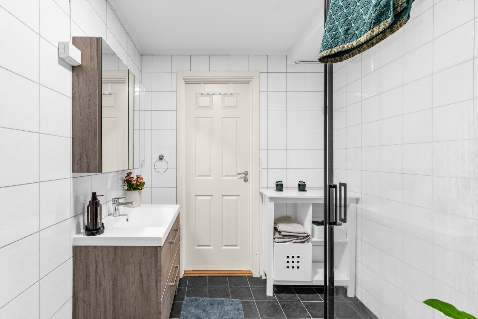 Bad 2 har flislagte overflater med varmekabler, servantseksjon med skuffer og overskap med speilfronter. Galleribilde